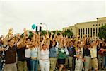 Large group of people waving their arms at a gay parade