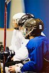 Side profile of three ice hockey players wearing helmets