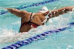 Vue arrière d'une femme nager dans une piscine