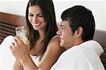 Close-up of a young woman and a mid adult man toasting with champagne flutes