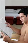 Seitenansicht eines jungen Mannes Lesen einer Zeitung