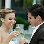 Side profile of a bride and her groom toasting with champagne flutes