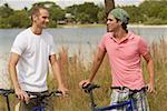 Deux jeunes hommes debout avec vélos
