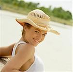 Portrait of a teenage girl posing against a wooden bench and smiling