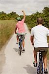 Rear view of two young men riding bicycles