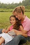 Mature woman and her daughter sitting in the park