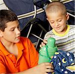 Close-up of a boy and his brother holding a water bottle