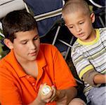 High angle view of two boys sitting together and looking at a flashlight