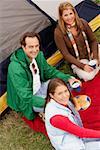Portrait eines Mädchens sitzen mit ihren Eltern in der Nähe von einem Zelt