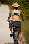 Rear view of a teenage girl riding a bicycle