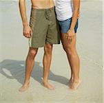 Young man and a teenage girl standing on the beach