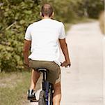 Rear view of a young man riding a bicycle