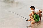 Side profile of a father and his son fishing