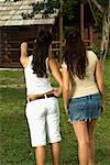 Rear view of two teenage girls standing in the garden