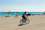 Seitenansicht eines Mannes Radfahren am Strand