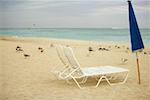 Chaise vide et un parasol plié sur la plage