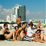 Men and women sunbathing on the beach