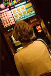 Vue arrière d'une femme assise en face de la machine à sous Las Vegas, Nevada, USA