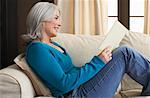 Woman Reading Book on Sofa