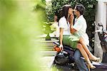 Man Kissing Woman on Scooter