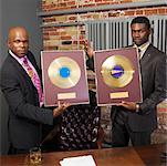 Record Executives Holding Gold Records