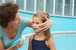 Mother Applying Sunscreen for Daughter