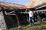 Man Standing by Decrepit Building