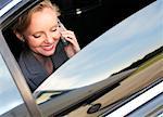 Businesswoman Using Cellphone in Car at Airport