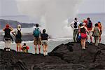 Touristes debout sur la lave, en regardant l'océan, Hawaii, USA