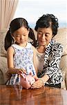 Grandmother and Granddaughter with Piggy Bank