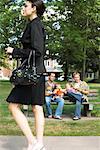 Woman Walking past Men with Babies in Park