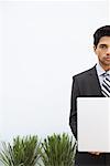 Portrait of Businessman Holding Laptop Computer