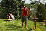 Man Spraying Woman With Hose