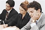 Businessmen sitting in a conference room with his eyes closed