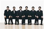 Portrait of a group of young men sitting on chairs