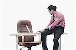 Profil de côté d'un homme d'affaires assis sur une table de travail sur un ordinateur portable
