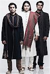 Portrait de trois jeunes hommes portant des tenues de mariage