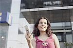 Low angle view of a young woman holding a mobile phone