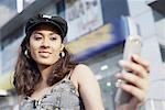 Low angle view of a young woman holding a mobile phone