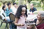 Mature woman and a girl holding a cake