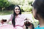 Teenage girl sitting with her friend holding a cup of tea