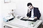 Homme d'affaires assis dans un bureau parlant au téléphone