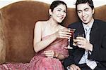 Jeune couple griller avec martini et whisky, verres