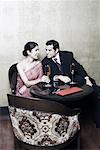 Businessman and a businesswoman sitting on chairs with champagne flutes