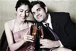 Close-up of a businessman and a businesswoman holding champagne flutes