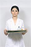 Portrait of a female nurse holding a tray