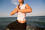 Jeune femme de faire des exercices d'yoga au bord de mer
