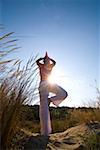 Young woman exercising on sand dune