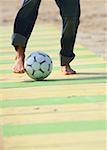 Male practicing soccer on beach