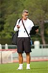 Trainer in sunglasses checking clipboard